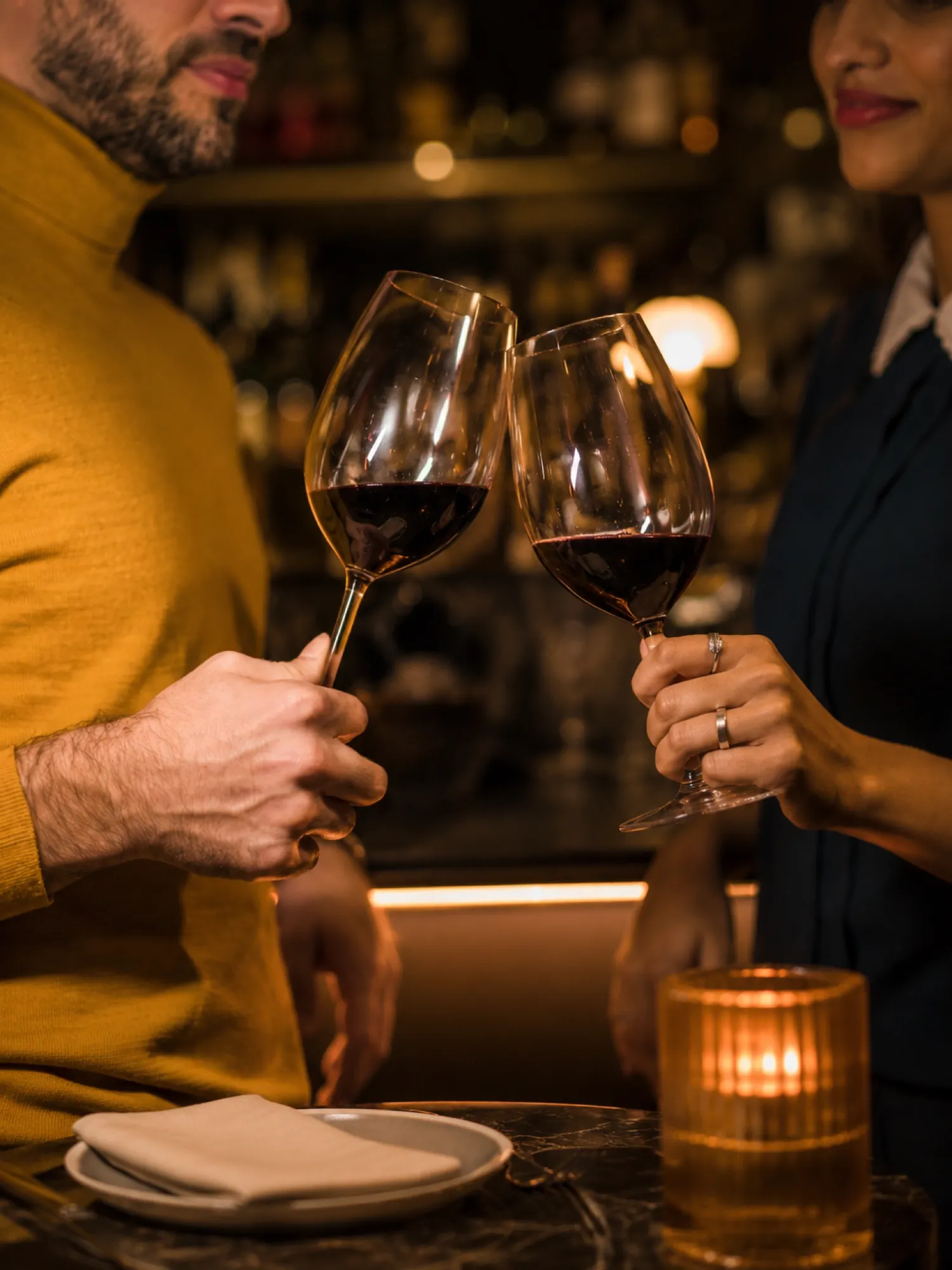 Pareja brindando con copas de vino tinto